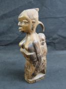 An African hardwood carved fertilty figure of mother with baby on back, standing 31cm high.
