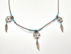 A silver and turquoise Native American bead dream catcher style necklace.