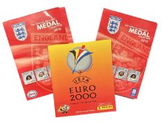 A pair of England football 2010 medal collections in folders, together wuth Euro 2000 Panini sticker