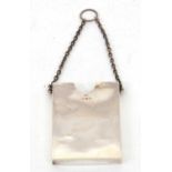 An Edwardian silver card holder of plain rectangular form, suspended from a silver oval link chain