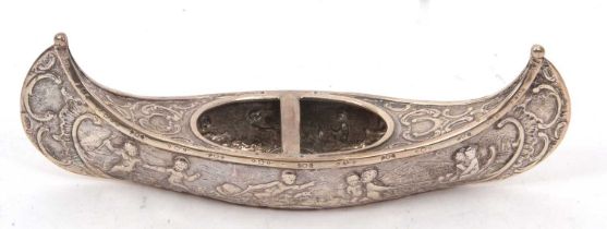 A Dutch silver "Canoe" shaped dish/ashtray, elaborately decorated with cherubs, scrolls etc,