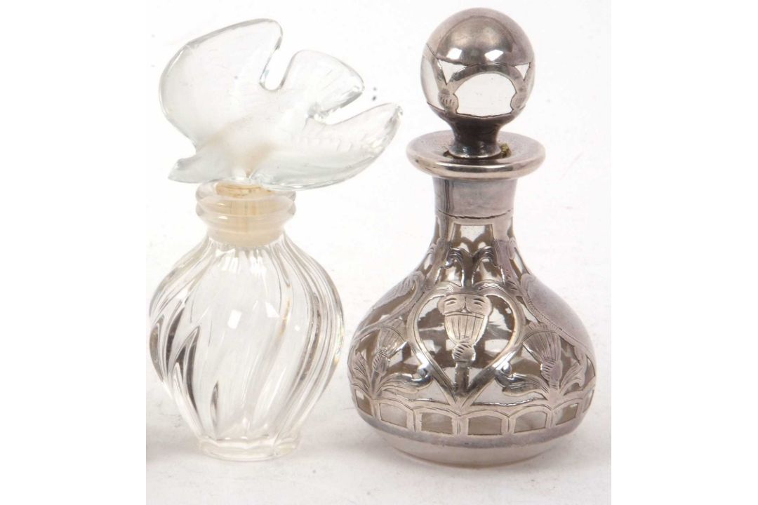 A Lalique, France Nina Ricci mini perfume bottle of wrythen turned form with a glass dove stopper, - Image 1 of 3