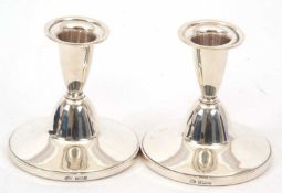 A pair of Elizabeth II silver dressing table candlesticks of plain form, loaded bases, hallmarked