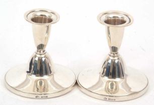 A pair of Elizabeth II silver dressing table candlesticks of plain form, loaded bases, hallmarked