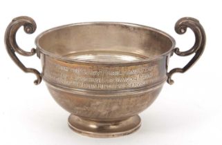 A George V silver twin handled pedestal bowl of compressed circular form, applied reeded rims,
