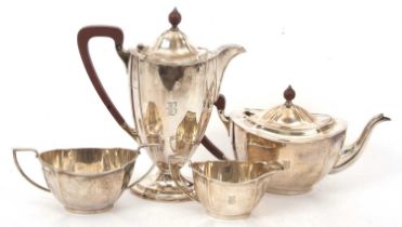 An Art Deco four piece silver tea set of oval panel form, comprising teapot, hot water/coffee jug,