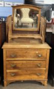 A late 19th Century oak dressing chest with an arched mirrored back over a body with three drawers