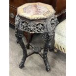 A late 19th or early 20th Century Chinese hardwood jardiniere stand with an octagonal marble inset