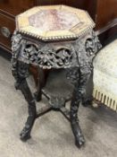 A late 19th or early 20th Century Chinese hardwood jardiniere stand with an octagonal marble inset