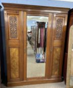 Late Victorian walnut wardrobe with central mirrored door and carved floral panels