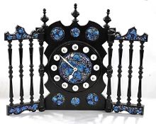 A 20th Century Spanish mantel clock with ebonised frame and enamelled panels, bearing label to the