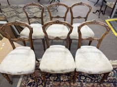 A set of six late 19th Century walnut dining chairs, the frames with carved decoration and turned