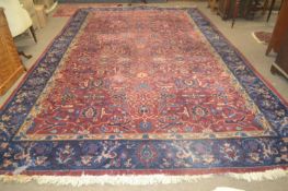 A large Turkish blue and red ground thick pile carpet decorated with stylised foliage and