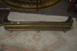 An early 19th Century brass and steel pierced fire fender of curved form raised on paw feet, 136cm