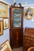 A 19th Century mahogany two section corner cabinet, the top section with a scrolled cornice over