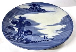 A large Japanese porcelain charger Meiji period painted with an island scene with Mount Fuji in