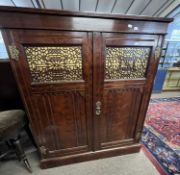 A late Victorian mahogany side cabinet with two doors inset with fretwork panels opening to a