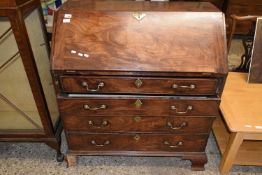 A George III mahogany bureau, the full front opening to an interior with small drawers and pigeon