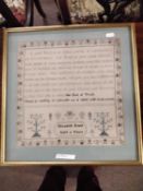 A needlework sampler decorated with a stylised floral border and rows of religious text singed