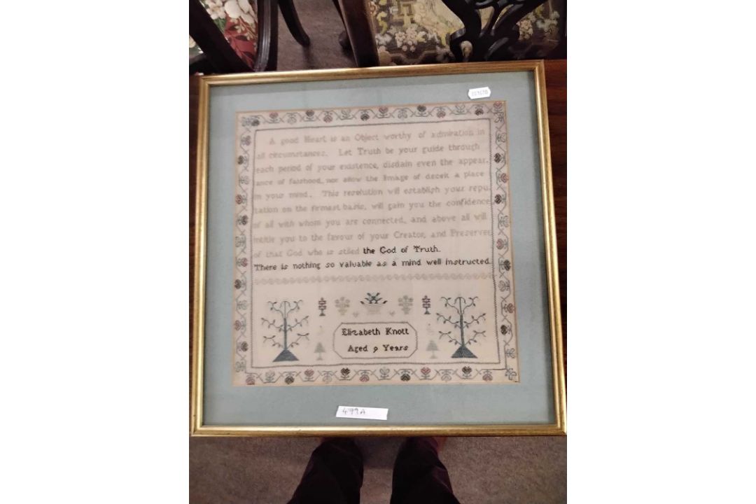 A needlework sampler decorated with a stylised floral border and rows of religious text singed - Image 1 of 4