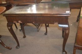 A Georgian mahogany games table of hinged rectangular form raised on cabriole legs with pad feet,