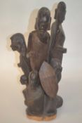 An African wooden carved group of warriors and children, 45cm high