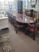 A Georgian Revival mahogany triple pedestal dining table together with an accompanying set of ten