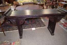 A Chinese hardwood altar table, the top with curved ends over carved support brackets and panelled