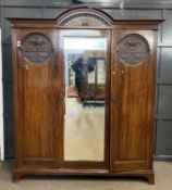 A large 19th Century walnut wardrobe with arched cornice with sunburst decoration over a body with a