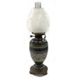 A 19th Century Doulton Lambeth oil lamp, the body decorated with three incised roundels of snakes