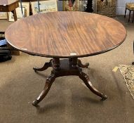 A Georgian mahogany dining table, the oval top supported on four turned columns and a platform