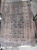 An antique Middle Eastern wool floor rug decorated with a large central panel on a mainly brown