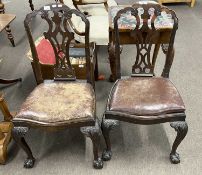 A pair of Georgian Revival mahogany dining chairs with leather upholstered drop-in seats and