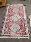 A 20th Century Afghan Kilim rug decorated with stylised animals on a principally red background,