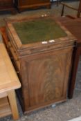 An early Victorian mahogany Davenport desk with sloped front with a tooled leather writing