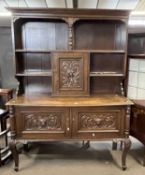 A Victorian Gothic carved oak dresser, the top section with moulded cornice over shelves and a