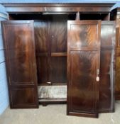 An Edwardian mahogany triple wardrobe with moulded cornice over three panelled doors with beaded and