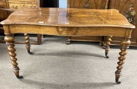 A Victorian walnut centre table of serpentine form, fitted with two frieze drawers and supported