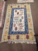 A 20th Century Kilim rug with a blue and yellow border surrounding a central panel with stylised