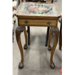 An early 20th Century lamp table, the top inset with a tapestry panel under glass, the body with a