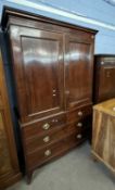 A Georgian mahogany linen press with a moulded cornice over two panelled doors opening to an