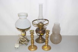 An oil lamp, another converted for electricity and a pair of brass candlesticks