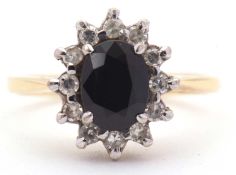 An 18ct sapphire and diamond cluster ring, the central oval sapphire surrounded by single cut