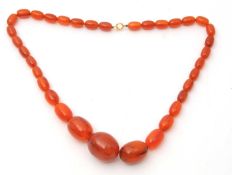 An amber bead neckclace, with graduated oval beads between approx. 10 - 25mm diameter, 62cm long,