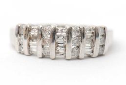 A 9ct diamond ring, set with round brilliant and tapered baguette cut diamonds, with tapered