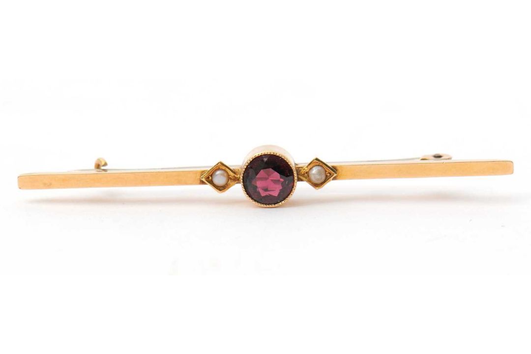 A garnet and seed pearl bar brooch, with central round garnet in millegrain collet mount, with a - Image 1 of 3