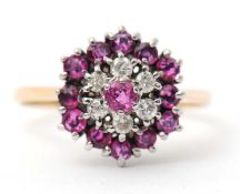 A ruby and diamond cluster ring, with central ruby surrounded by small round diamonds and further