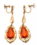 A pair of citrine earrings, with pear shape citrines set within a moulded frame, suspended below a