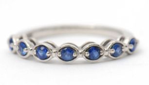 A platinum sapphire ring, with seven round sapphires in oval mounts, with plain band hallmarked
