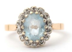 A 9ct topaz and diamond cluster ring, the central oval topaz surrounded by small single cut